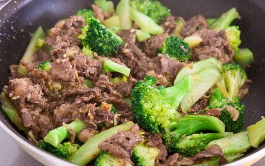 1. Этап. Брокколи и говядина: 5. Откройте крышку и добавьте мясо, в отдельной емкости смешайте оставшийся крахмал с куриным бульоном, устричным соусом, молотым перцем, вылейте все в сковороду. Перемешайте все содержимое и готовьте несколько минут.