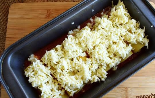 1. Этап. Рулеты из лазаньи: 4. В форму для запекания вылейте томатный соус. Опустите фаршированные рулетики лазаньи, сверху посыпьте тертой моцареллой.