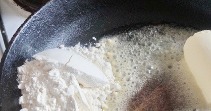 1. Этап. Мясо с грибами под соусом: Приготовьте соус: растопите сливочное масло и добавьте к нему муку. Перемешайте всё на сковороде.