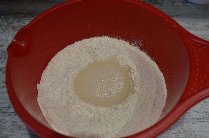 1. Этап. Пшеничный багет: Сделайте в муке углубление и влейте в него воду температурой 27 градусов.