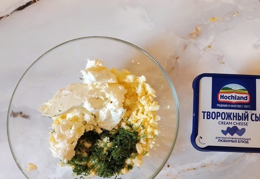 1. Этап. Треугольники из лаваша с начинкой: К нарезанным яйцам добавить творожный сыр Hochland, нарезанный укроп. Посолить, поперчить.