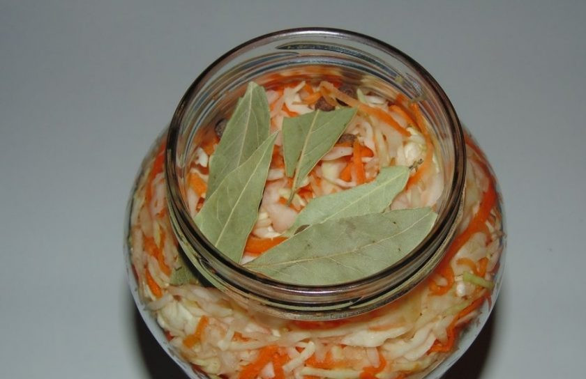 1. Этап. Засолка капусты горячим рассолом: Уложите овощи в 2-х литровую банку. Сверху положите перец и лавровый лист.