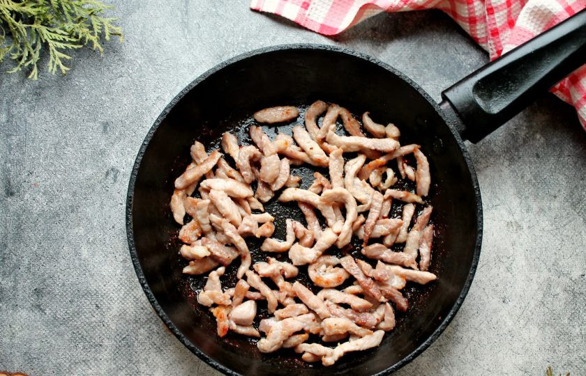 1. Этап. Салат из редьки с жареным мясом: Мясо, у меня свинина, сполосните, обсушите и порежьте тонкой соломкой. Свинину немного посолите, поперчите и выложите в сковороду с горячим растительным маслом. Обжаривайте мясо до румяной корочки, примерно в течение 5-7 минут, до готовности. Переложите обжаренное мясо на бумажную салфетку, чтобы оно остыло и стекло масло.