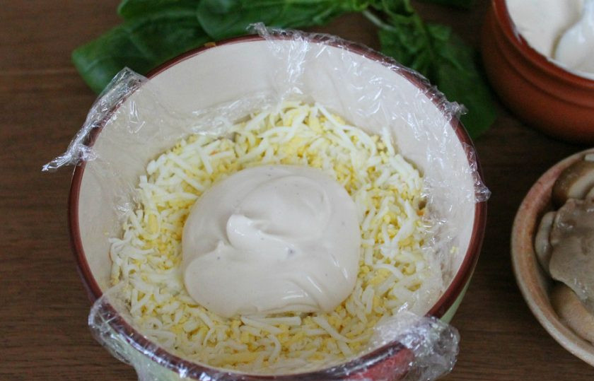 1. Этап. Салат Зимнее солнце: Следующим слоем высыпаем тертые на терке вареные яйца и добавляем соус.