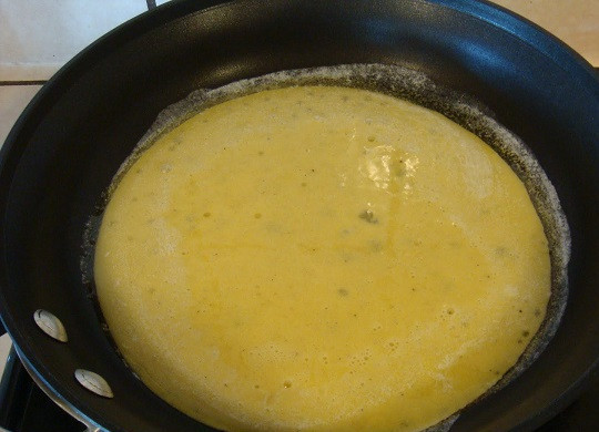 1. Этап. Омлет с куриным филе: 7. На отдельной сковороде разогреть немного сливочного или растительного масла и вылить туда яйца. Пока они будут жариться, можно сыр натереть на средней терке.