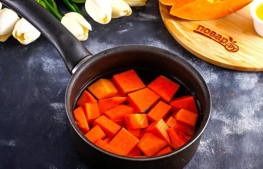 1. Этап. Тыквенное пюре: Влейте горячую воду и поместите емкость на плиту, включая умеренный нагрев. Отварите кусочки овоща примерно 15-20 минут до мягкости.