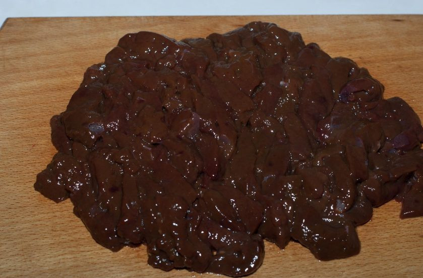 1. Этап. Печень говяжья по-строгановски: Промойте печень под холодной проточной водой, зачистите от пленок и прожилок и нарежьте небольшими кусочками.