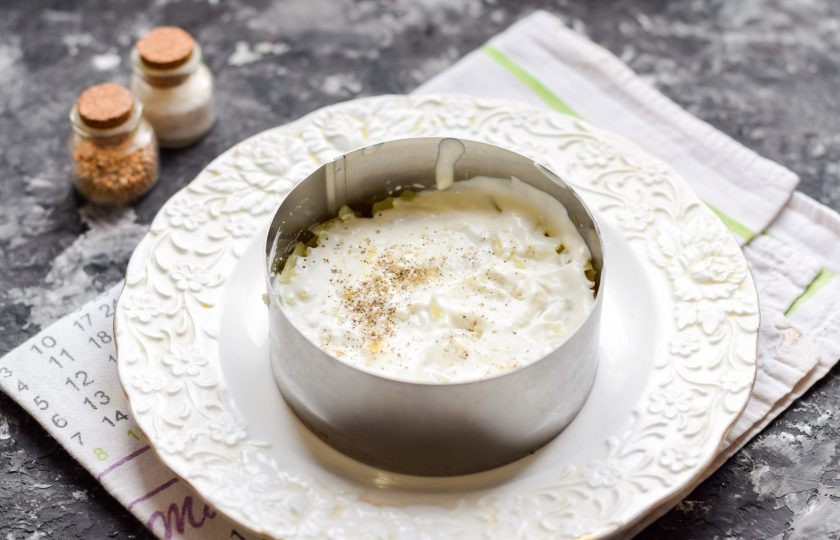 1. Этап. Салат Мимоза с красной рыбой: Смажьте слой салата майонезом, добавьте соль и перец по вкусу. Далее также смазывайте салат майонезом в небольшом количестве.