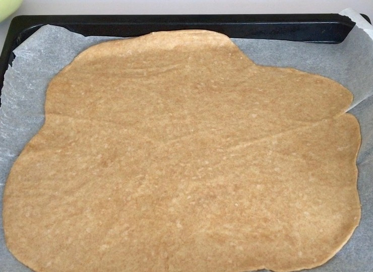 1. Этап. Отрубная галета с тыквой и фетой: Отдохнувшее тесто раскатайте между двумя листами бумаги для выпечки и уложите на противень.