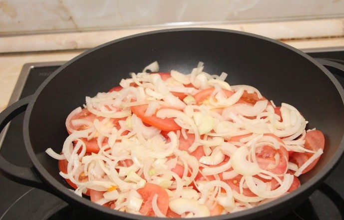 1. Этап. Хашлама из баранины на пиве: На помидоры выкладываем половину нарезанного полукольцами репчатого лука.