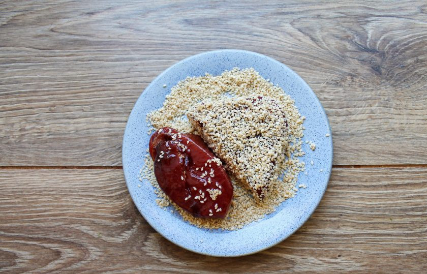 1. Этап. Стейк из тунца в кунжуте: В тарелку насыпьте кунжут, выложите замаринованные стейки и полностью покройте их семенами.