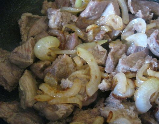 1. Этап. Жаркое из картошки: В той же сковороде обжарьте говядину, добавив растительного масла. Минут через 10 выложите на мясо половину лука, сверху картофель, посолите и поперчите.