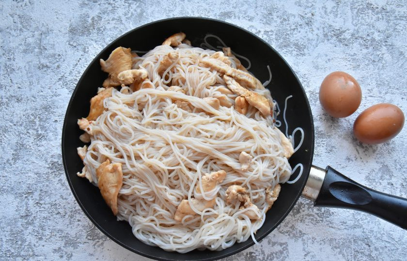 1. Этап. Рисовая жареная лапша Пад Тай: Не убавляя огонь, добавьте к мясу подготовленную рисовую лапшу и заправку, хорошенько перемешайте составляющие блюда между собой.