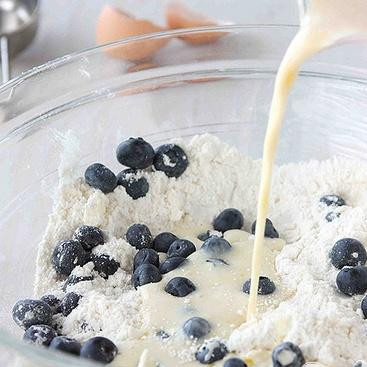 1. Этап. Лепешки с черникой: 3. В мерной чашке взбить яйца, молоко и ванильный экстракт. Добавить яичную смесь в сухие ингредиенты и перемешать вилкой, пока не получится однородное тесто. При желании на этом этапе вы можете добавить в тесто мелко тертую цедру лимона.