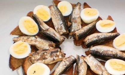 1. Этап. Гренки со шпротами: На кусочек обжаренной гренки кладем дольку яйца и одну шпротину.