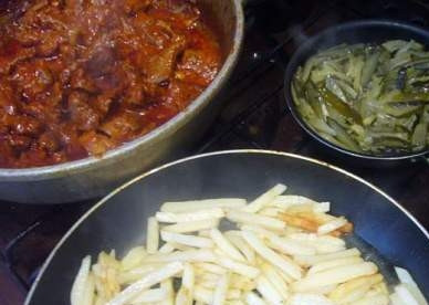 1. Этап. Азу из конины по татарски: Огурцы тушим в небольшом количестве воды. Картошку обжариваем до полуготовности. Затем отправляем и картошку, и огурцы в казан к мясу и тушим все вместе минут 20-30.