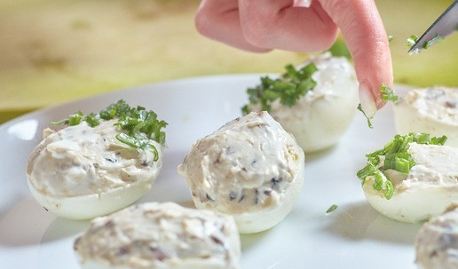 1. Этап. Фаршированные яйца с сыром: Украсить нижнюю широкую часть яйца зеленым луком.