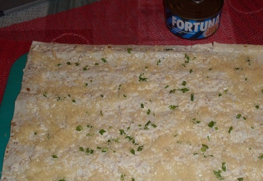 1. Этап. Рулет из лаваша Новогодний: Затем равномерно выкладываем на лаваш натертый сыр и зелень.