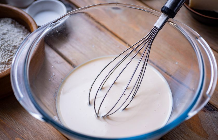 1. Этап. Тесто на топленом молоке: Залейте теплое топленое молоко и венчиком все размешайте до растворения дрожжей.