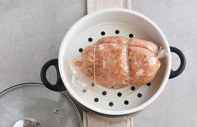 1. Этап. Домашняя ветчина из курицы: Выложите упакованную ветчину на решетку пароварки.