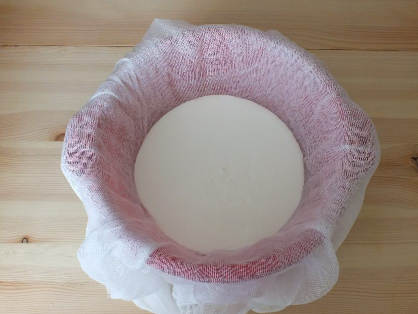 1. Этап. Сыр из кефира и сметаны: Возьмите дуршлаг, выстелите на него 4 слоя марли. Перелейте в него кефирно-сметанную массу.