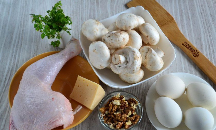 1. Этап. Салат с курицей и шампиньонами: Подготовьте все необходимые ингредиенты. Куриный окорок натрите солью и специями и запеките в духовке до готовности. Яйца отварите вкрутую.