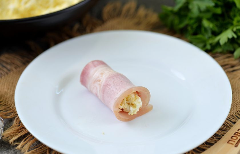 1. Этап. Рулетики из бекона с сыром и яйцом: Скрутите бекон с начинкой в рулетик. То же самое сделайте с оставшимися ингредиентами.
