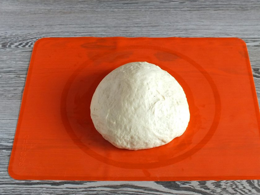 1. Этап. Пончики в хлебопечке: Готовое тесто переложите на стол. Сделайте обминку. Если тесто прилипает к рукам, смажьте руки растительным маслом.