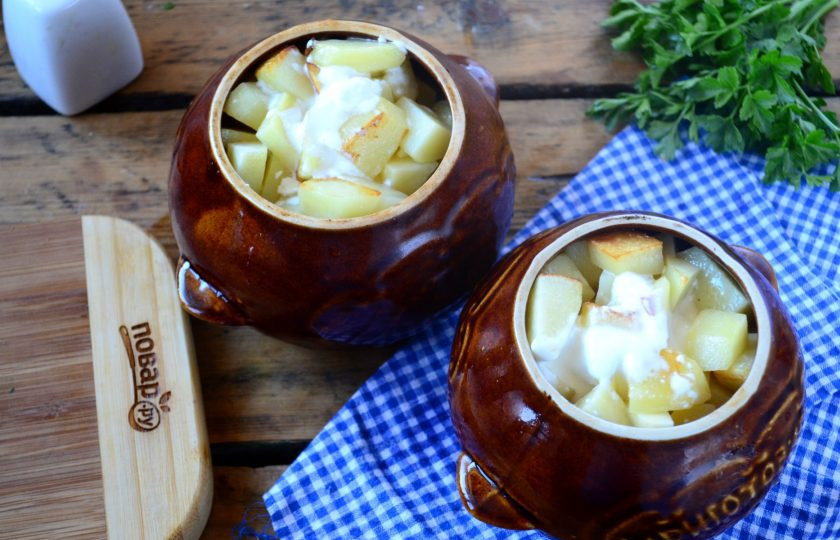 1. Этап. Охотничьи колбаски с картофелем и шампиньонами в горшочках: Смешайте сметану с бульоном, еще немного присолите при необходимости, залейте полученной жидкостью горшочки примерно до половины.