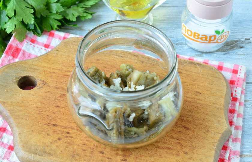 1. Этап. Баклажаны в духовке на зиму: На дно чистой простерилизованной банки влейте масло, уксус и всыпьте соль. Сверху выложите третью часть баклажанов. Выдавите немного чеснока — третью часть.
