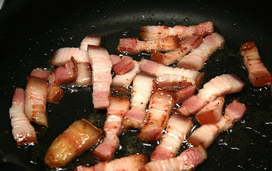 1. Этап. Кролик тушеный в горшочке: Бекон нарезать небольшими кусочками и обжарить на хорошо разогретой сковороде.