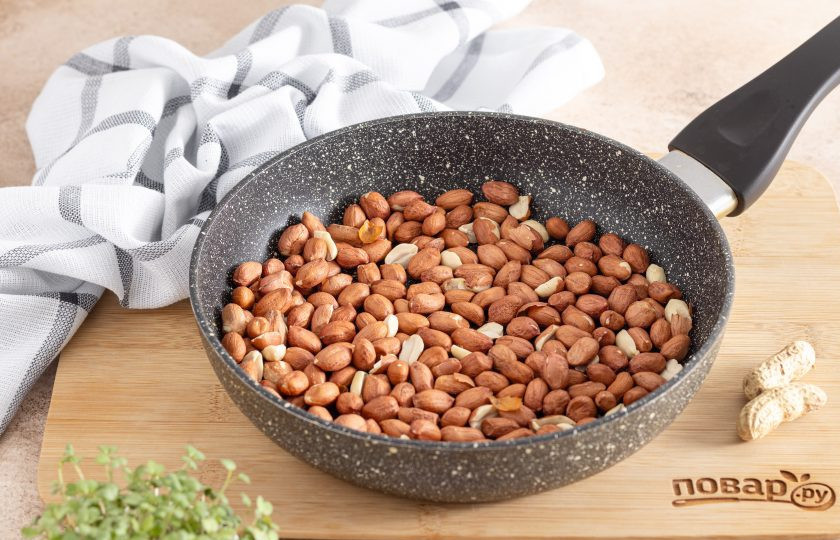 1. Этап. Арахис с солью на сковороде: Выложите в сухую сковороду арахис в один слой. Поставьте на плиту и на средней температуре начните обжаривать, периодически помешивая, чтобы арахис не пригорел.