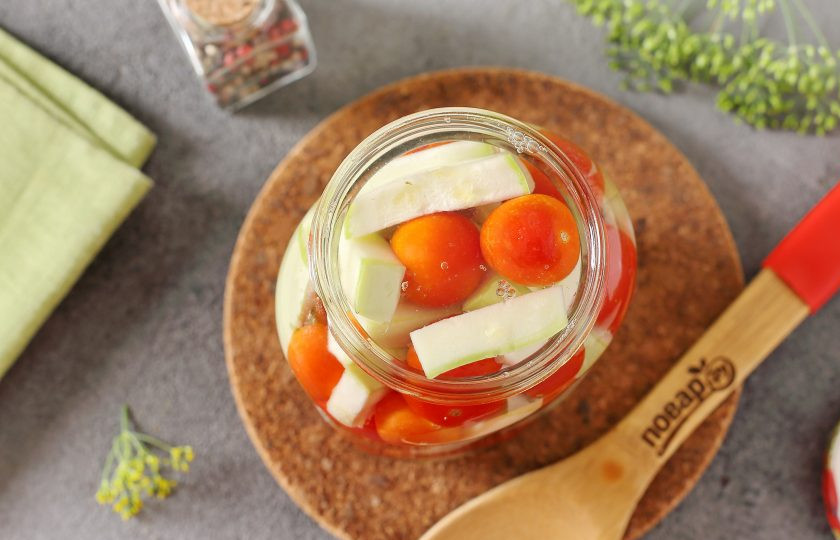 1. Этап. Ассорти из помидоров и кабачков на зиму: Налейте в банки кипяток, прикройте крышкой и оставьте на 10 минут.