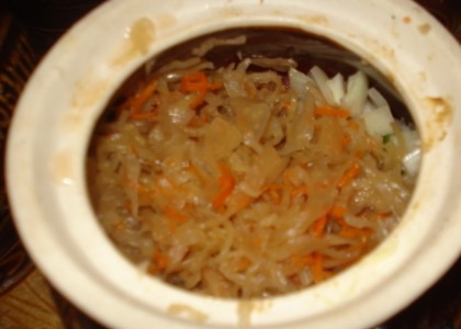 1. Этап. Свинина запеченная в горшочке: Затем идет квашеная капуста. Ее необходимо равномерно распределить и слегка примять вилкой.