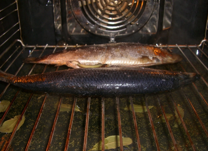 1. Этап. Копченая селедка: 3. Тем временем наливаем в противень жидкий дым и укладываем перец и лавровый лист. Перед отправкой рыбы на решетку над противнем, удаляем лишнюю соль. После этого выкладываем рыбу на решетку, которая должна располагаться сразу над противнем. Если в вашей духовке имеется режим 