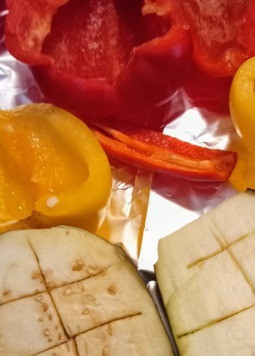 1. Этап. Восточно-европейское блюдо из жареных перцев: Разрезать баклажан на две половинки, и сделать на них надрезы крест-накрест глубиной 2см. Перцы очистить от зёрен и грубо порезать. В форме для запекания соединить 2 столовые ложки оливкового масла с одной чайной ложкой соли, равномерно обвалять в масле баклажан, сладкие перцы, а также жгучий перец. Овощи запекать при 230С 35 минут.