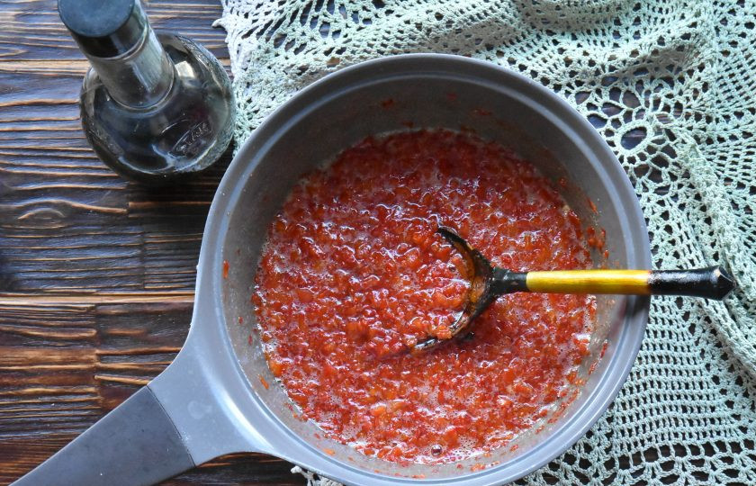 1. Этап. Джем из красного перца чили: Переложите перец в емкость, добавьте сахар и бутончики гвоздики. Перемешайте и дождитесь выделения сока.