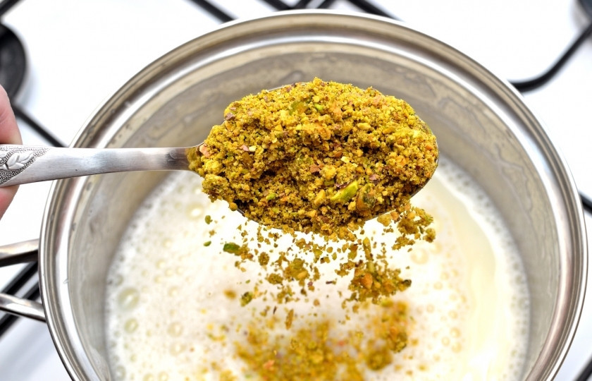 1. Этап. Кулфи: Высыпьте измельчённые фисташки и мускатный орех.