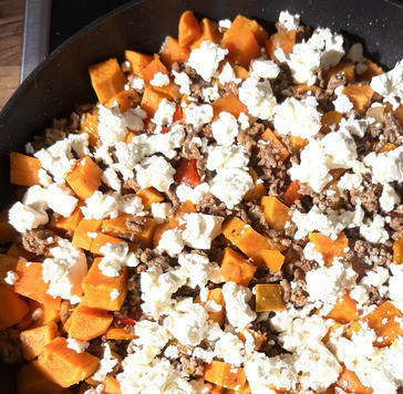 1. Этап. Батат с фаршем и фетой: Фету покрошить в сковороду, перемешать и дать расплавиться сыру.