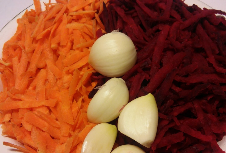 1. Этап. Маринованная капуста с чесноком: Свеклу и морковь промываем, очищаем и трем на крупной терке. Чеснок очищаем и нарезаем дольками.