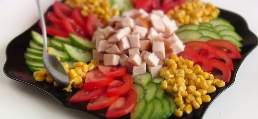 1. Этап. Салат праздничный за 10 минут: 2. Выложите салат в виде солнца: в центр выложите нарезанную куриную грудку, далее аккуратно выложите полукольца огурцов от центра к краям, затем также выложите помидоры. Между огурцами и помидорами выложите кукурузу.