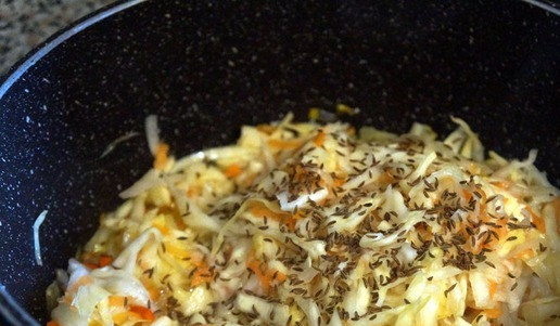 1. Этап. Солянка рыбная оригинальная: Если капуста квашена без тмина, можно добавить столовую ложку тмина. Перемешать, накрыть крышкой, убавить огонь до среднего и тушить 15 минут.