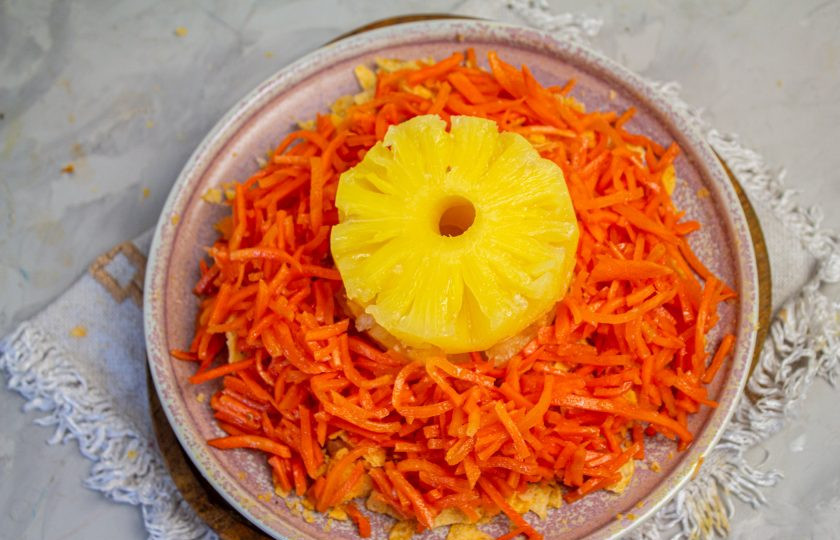 1. Этап. Салат Ананасовое кольцо: Поверх чипсов распределите морковь по-корейски. Если она очень длинная, то подрежьте ее ножницами.
