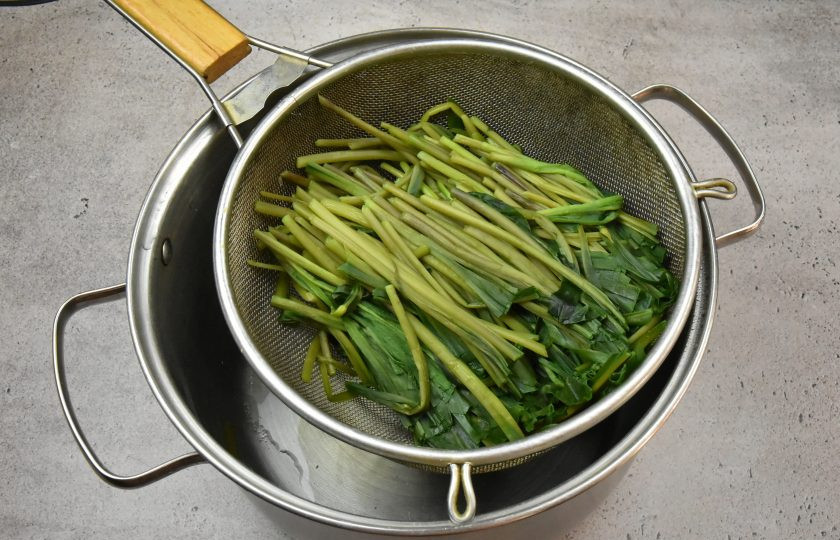 1. Этап. Черемша в томатном соусе на зиму: Отваренную зелень переложите в сито, чтобы стекла лишняя влага.