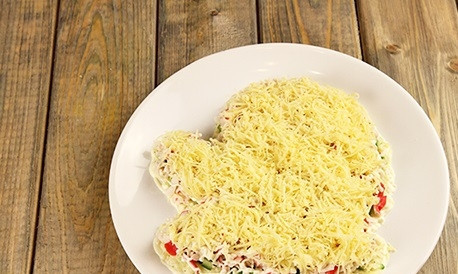 1. Этап. Салат Варежка Деда Мороза: 4. Натрите на средней терке сыр (отложите маленький кусочек для украшения салата перед подачей). Выложите сверху на палочки и промажьте майонезом.