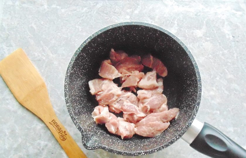 1. Этап. Гуляш с горохом: Мясо вымойте, нарежьте небольшими кусочками, как на гуляш. Выложите в кастрюлю с толстым дном или в сотейник.