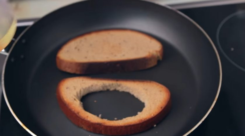 1. Этап. Суперсытный сэндвич на завтрак: 2. Хлеб нарежьте на ломтики толщиной 1 см. В одном ломтике вырежьте круг для яичницы. Обжарьте хлеб на сухой сковороде на небольшом огне до золотистой хрустящей корочки.