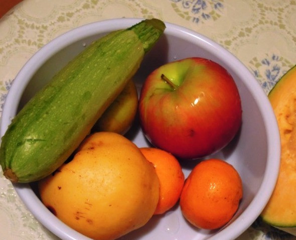 1. Этап. Курица с овощами и фруктами: Вымойте и очистите овощи и фрукты. Порежьте яблоки и груши пополам, тыкву и картофель — кубиками, кабачок — кружочками, мандарин и чеснок оставьте целыми. Также можно добавить айву, баклажаны и грибы.