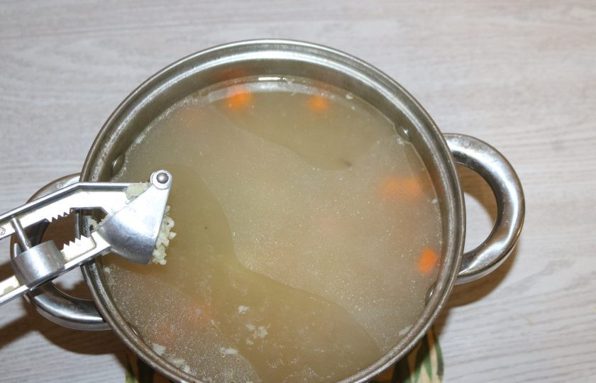 1. Этап. Суп с рожками: В бульон добавьте нарезанную морковь и картофель, мелко нарежьте или выдавите чеснок через чесночный пресс. Варите 15 минут.