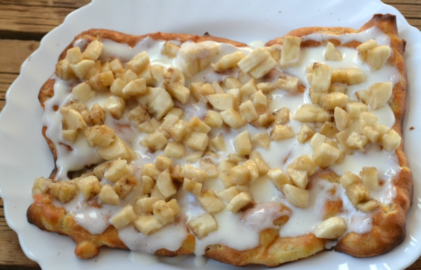 1. Этап. Торт из заварного теста с фруктами: На подходящую по размеру плоскую тарелку положите первый корж, обильно смажьте его сметанным кремом. Выложите сверху измельченные бананы.